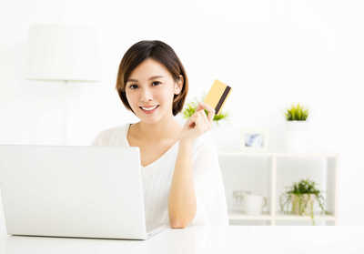 Women sitting down, smiling holding a credit card. Fees, Fee, Payment Option